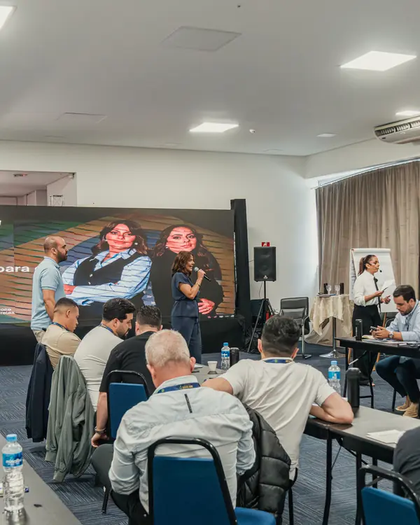 Sala da imersão com empresários e telão ao fundo